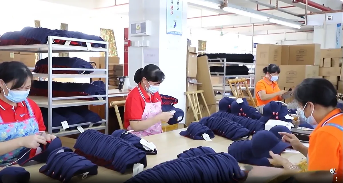 Workers finishing and checking completed hats in batches